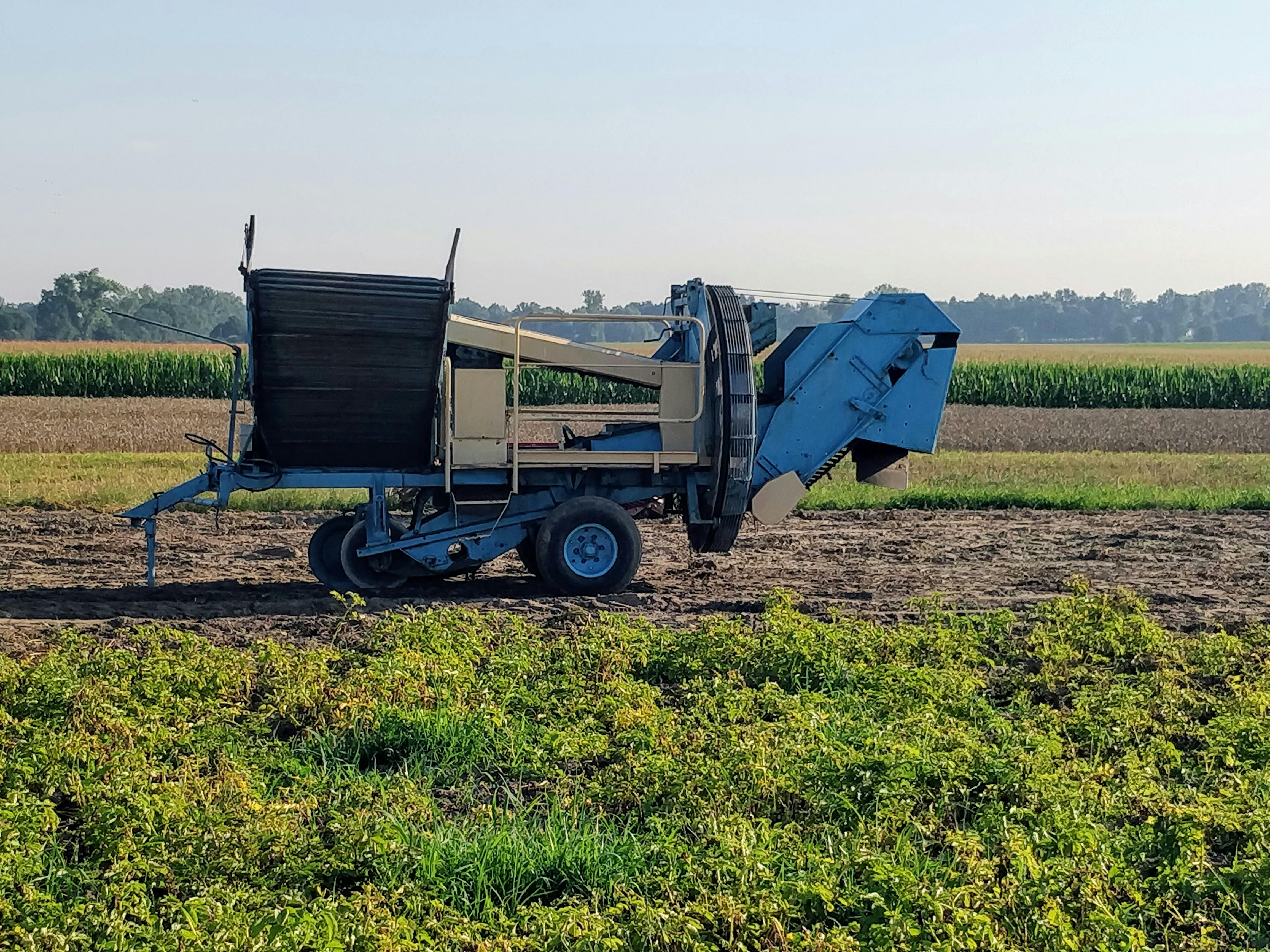 A close-up of agricultural machinery in a green field, showcasing farming technology in summer.