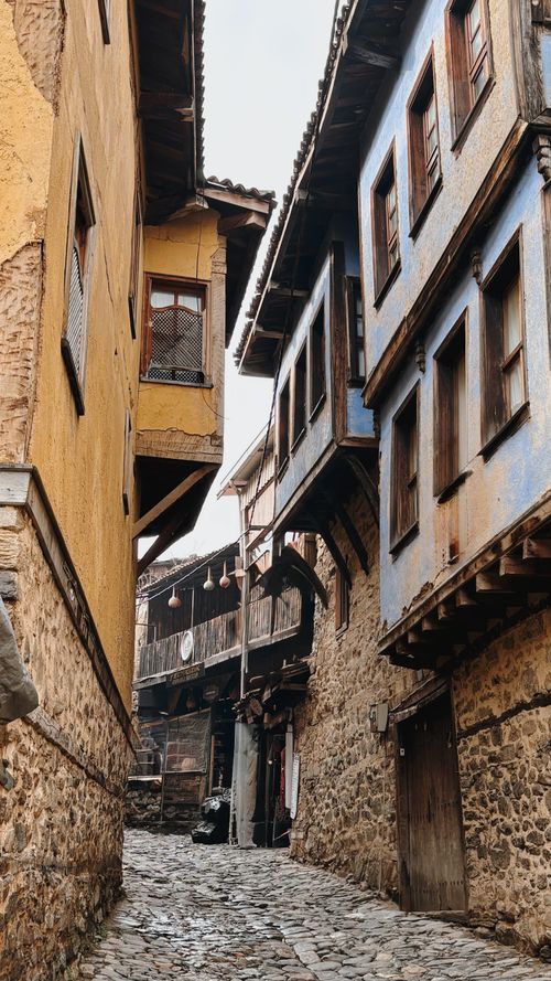 Free Quaint narrow alley with rustic stone buildings in historic village setting. Stock Photo