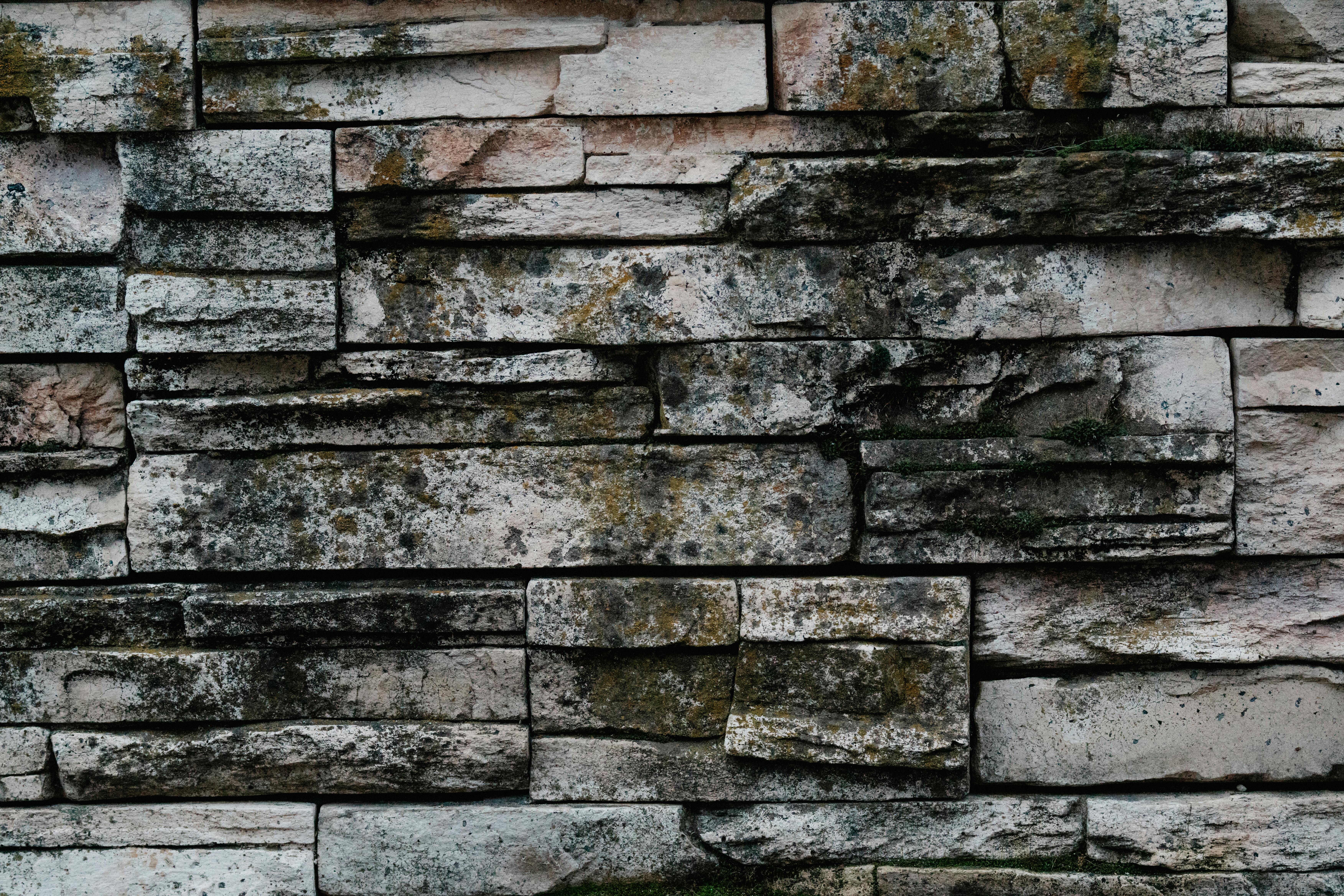Rustic mortared stone wall with moss and lichen patina