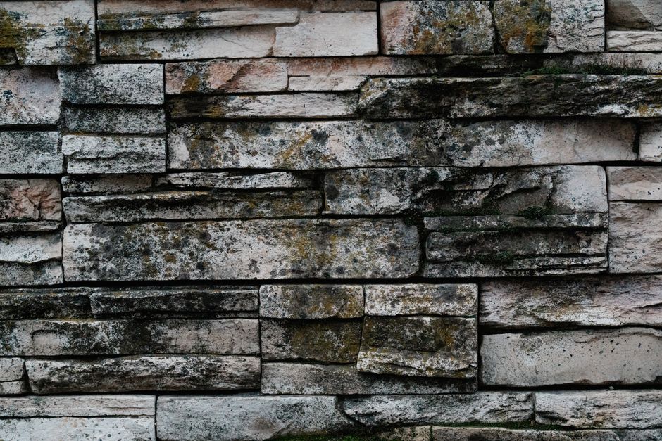 Close-up of a rustic stone wall with moss and lichen textures.