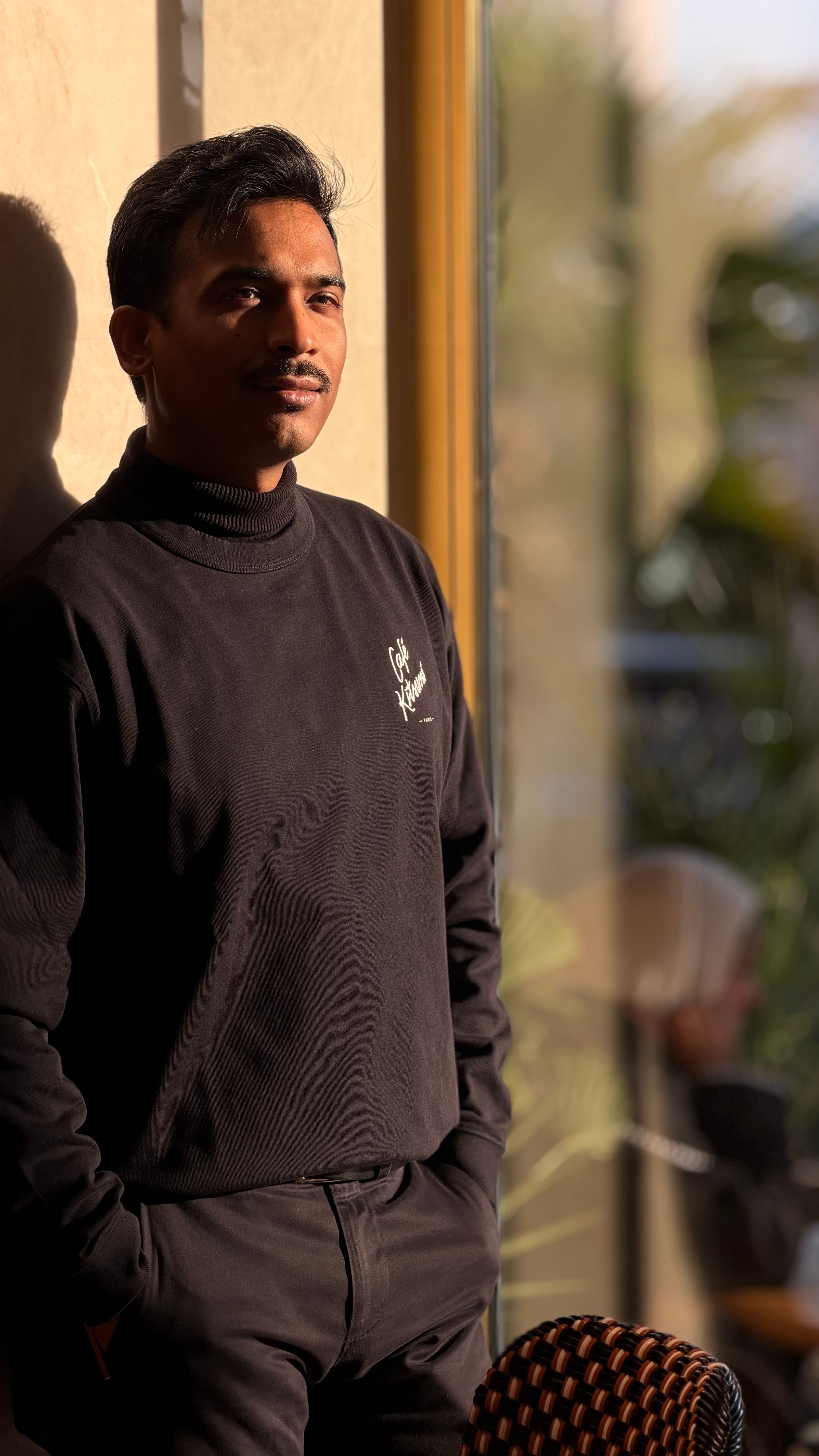 Thoughtful Man Stands by Sunlit Window Indoors