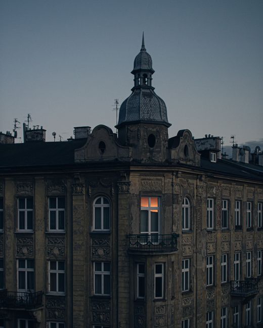 Elegant historic building in Kraków captured at twilight, showcasing intricate architecture.