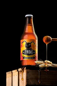 Peruvian craft beer with honey and wheat against a dark background.