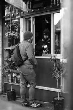 A candid black and white scene of customers at a Dublin café window.