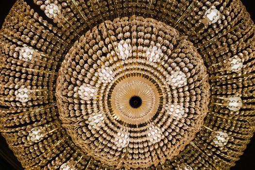 Dramatic perspective of an ornate crystal chandelier from below, highlighting intricate details.