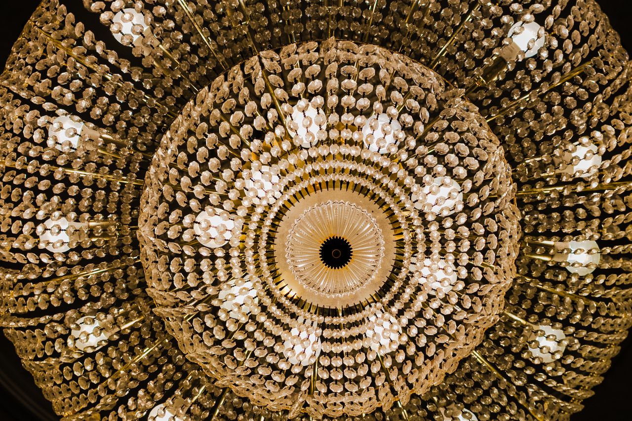 dramatic perspective of an ornate crystal chandelier from below highli