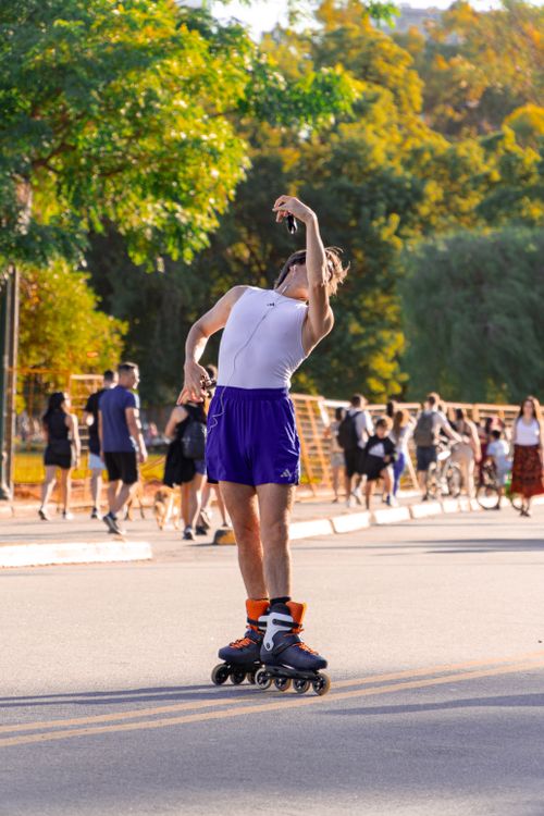 Free A young man performs graceful roller skating moves in a bustling Buenos Aires park. Stock Photo