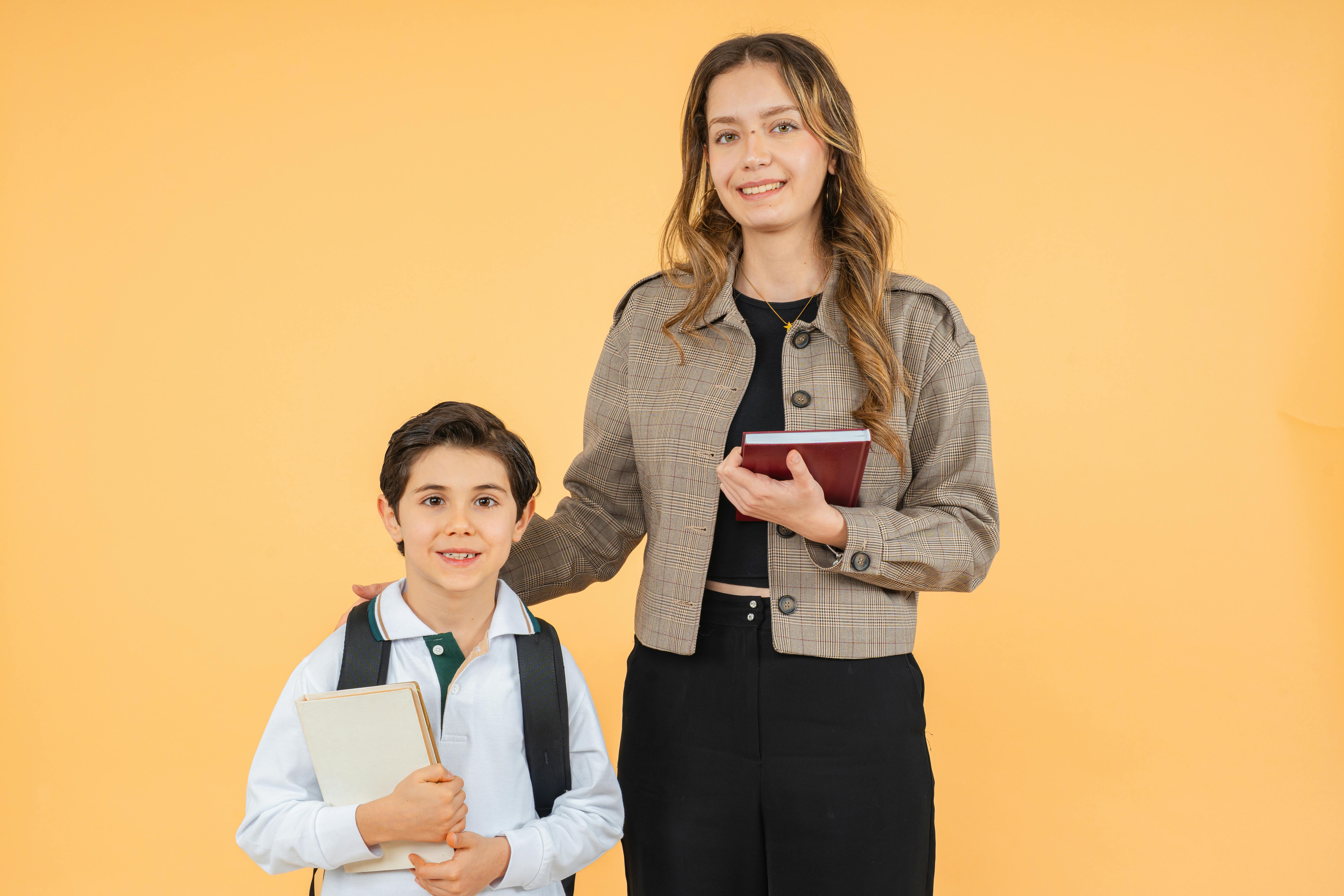 免費 教室裡，老師和學生面帶微笑，在色彩繽紛的背景下合照。 圖庫相片