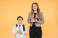 Smiling Teacher and Student Against Yellow Background