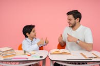 Teacher and student giving thumbs up in classroom