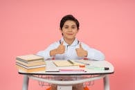 Smiling student with thumbs up in classroom setting