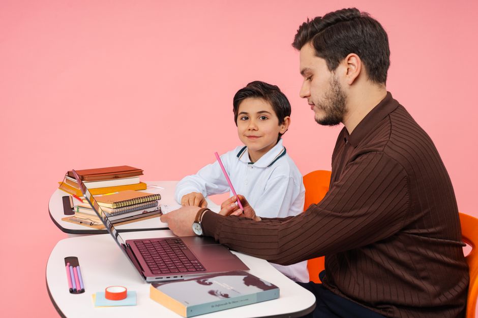 A teacher assists a student in a colorful classroom setting, fostering learning and education.