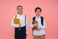 Smiling School Children Holding Books on Pink Background