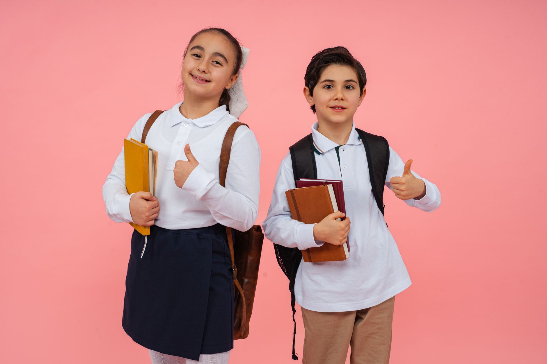 Okul üniforması ve sırt çantası taşıyan çocuklar