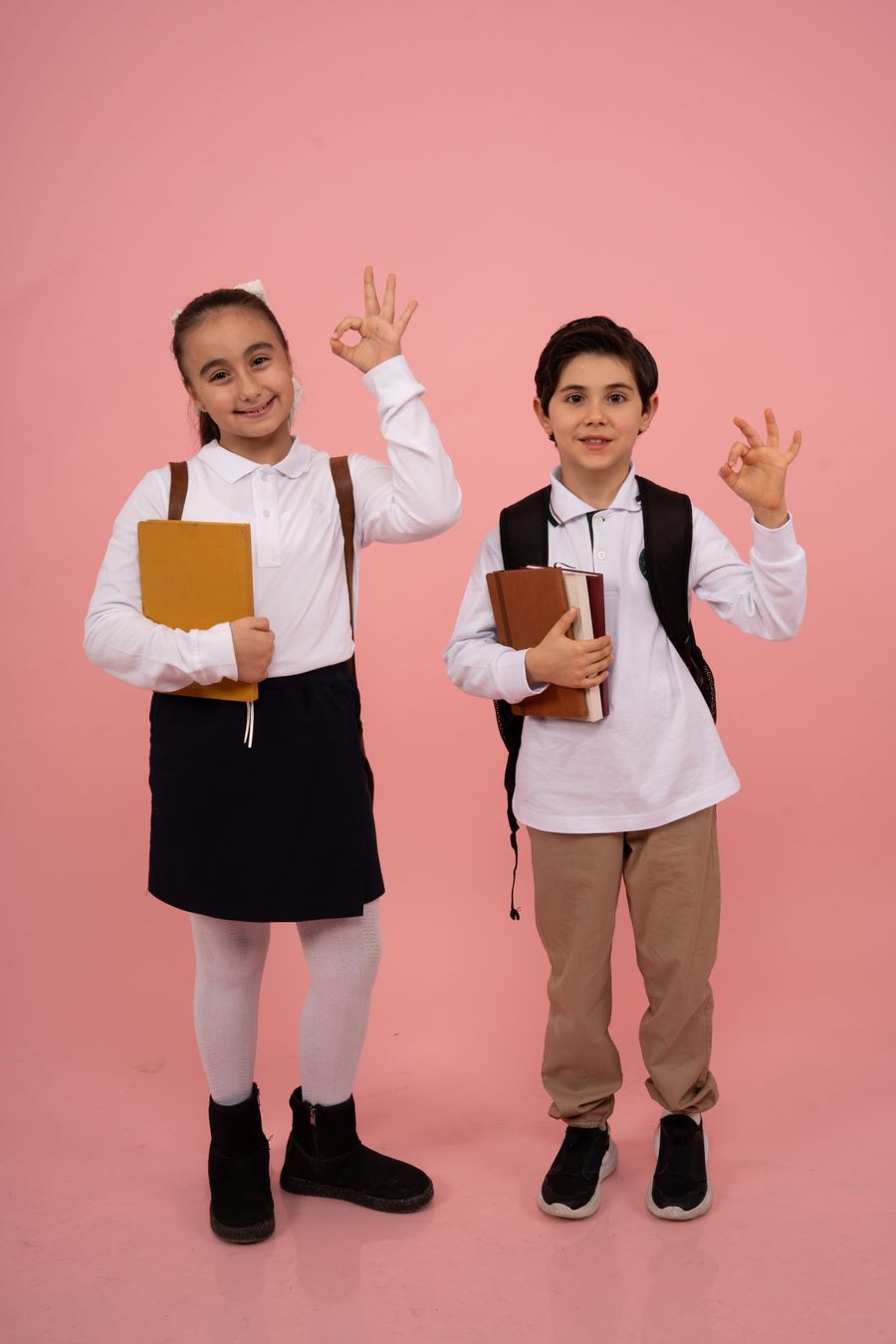 Cheerful schoolchildren posing with books