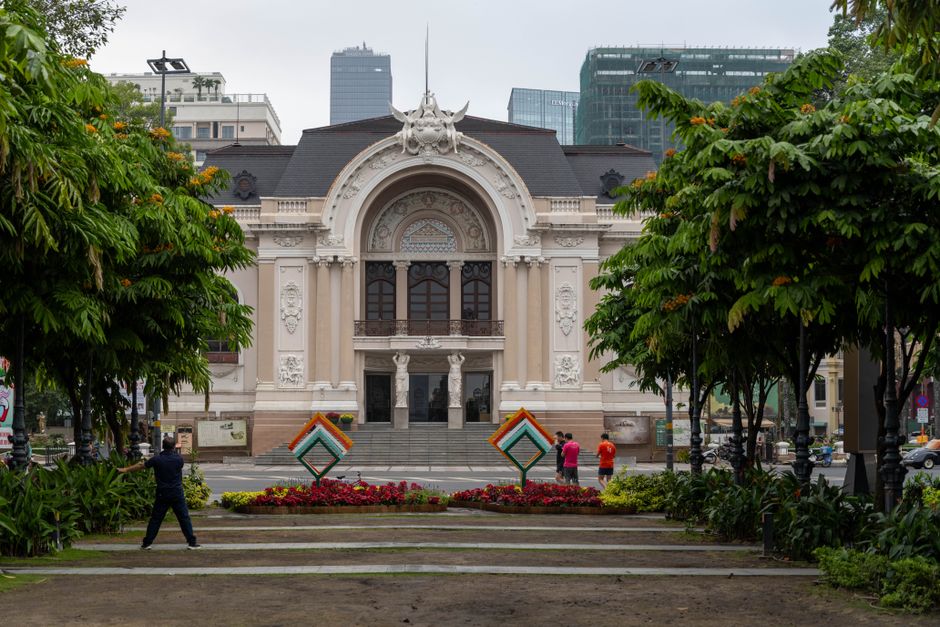 Stunning view of Saigon Opera House facade in Ho Chi Minh City, Vietnam, surrounded by vibrant greenery.
