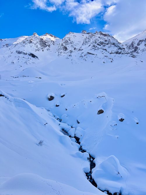 Free Breathtaking view of snow-covered mountains under a blue sky, capturing winter's serene beauty. Stock Photo