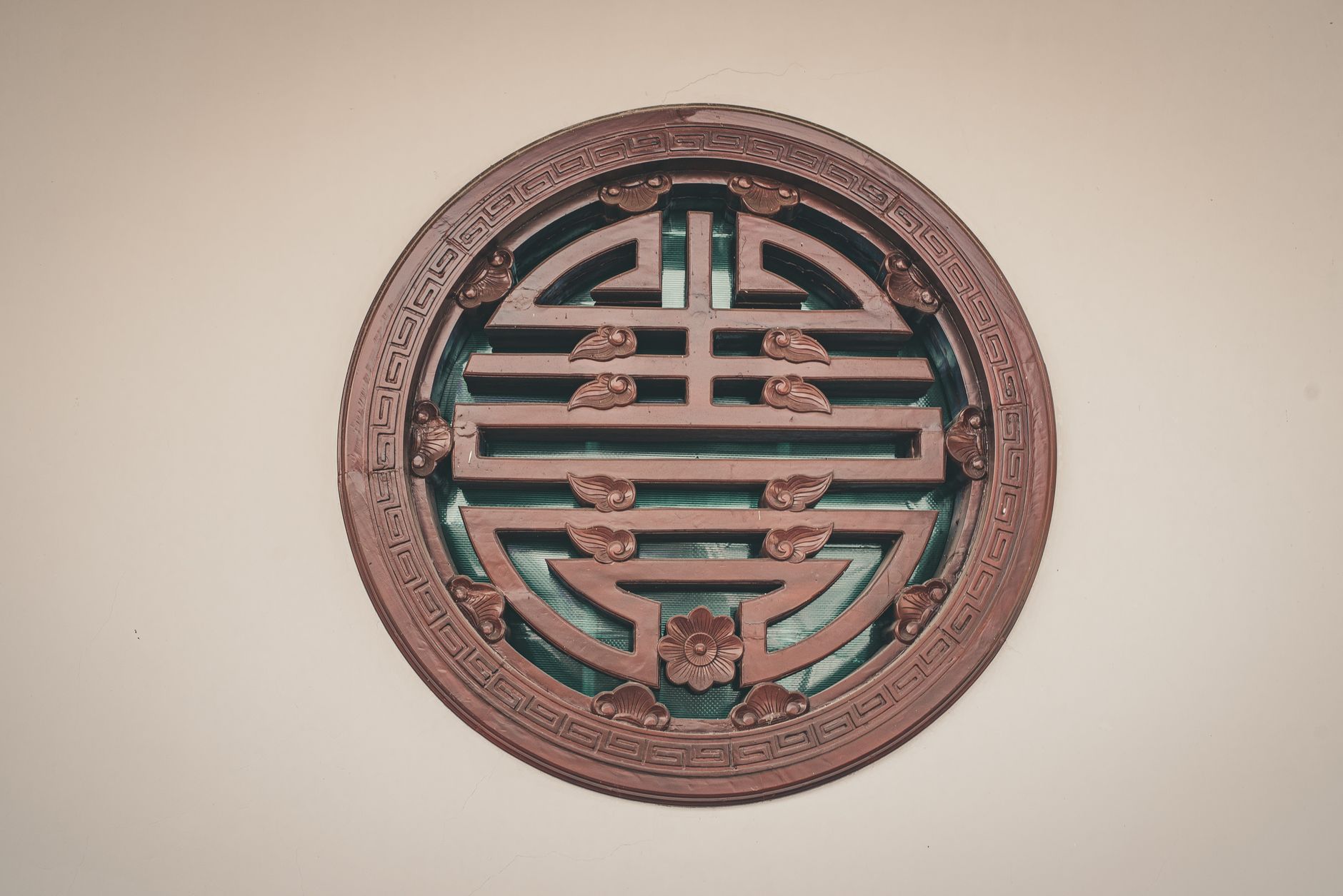 A close-up of a traditional Chinese circular wall decoration featuring intricate wooden designs.