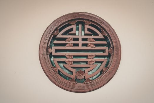 A close-up of a traditional Chinese circular wall decoration featuring intricate wooden designs.