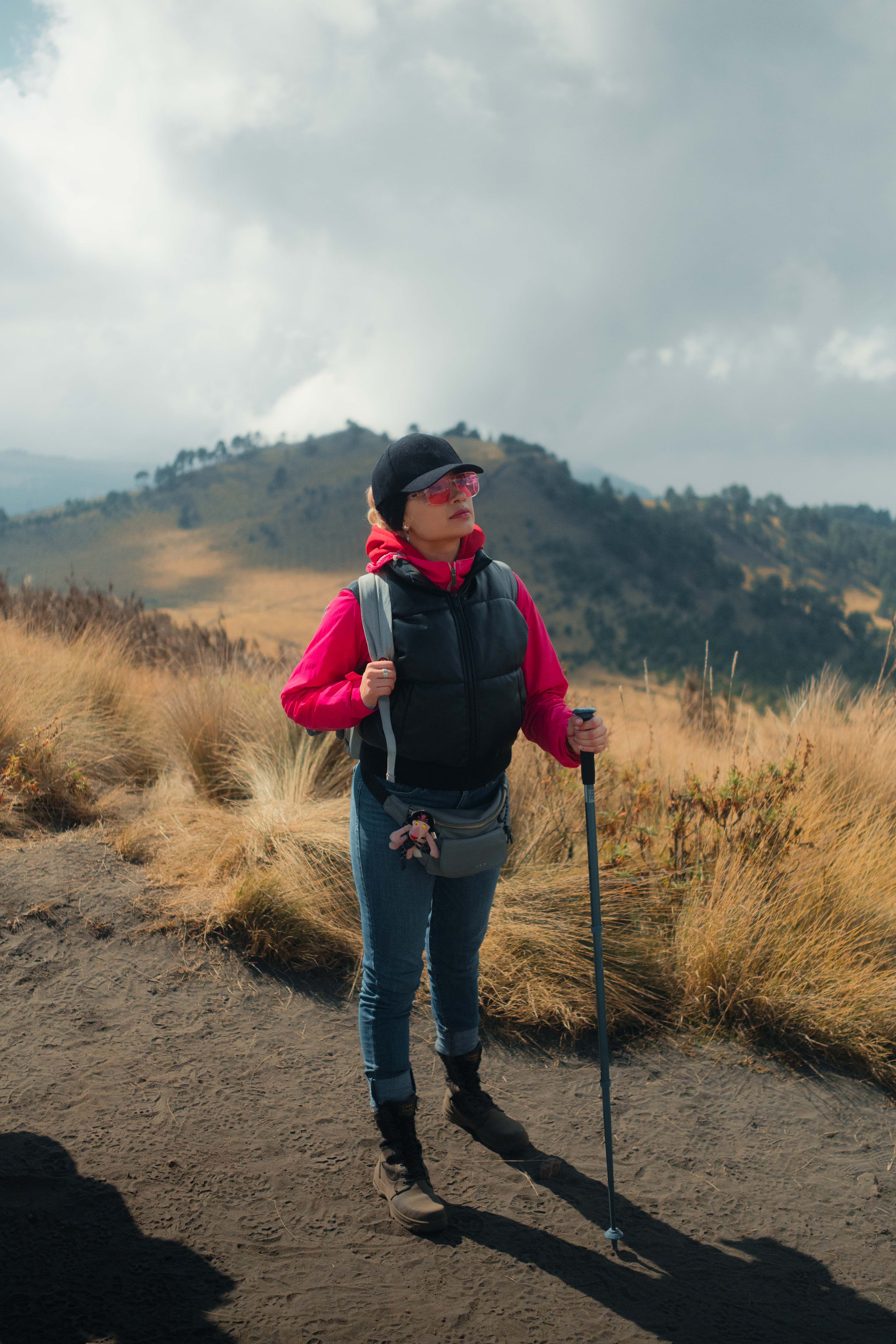 Woman enjoying a hike in the mountains, surrounded by stunning natural scenery and clouds.
