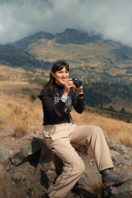 Free A female photographer captures picturesque mountain views on a sunny outdoor adventure. Stock Photo