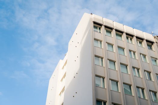 Low angle view of a modern urban building with a clear blue sky, showcasing architectural design.