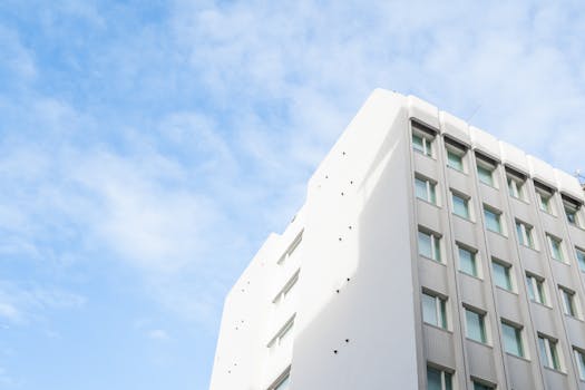 A minimalistic view of a modern urban building with a clear blue sky background.