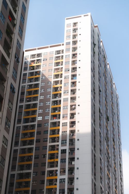 Free High-rise apartment building with blue sky backdrop, showcasing modern urban architecture. Stock Photo
