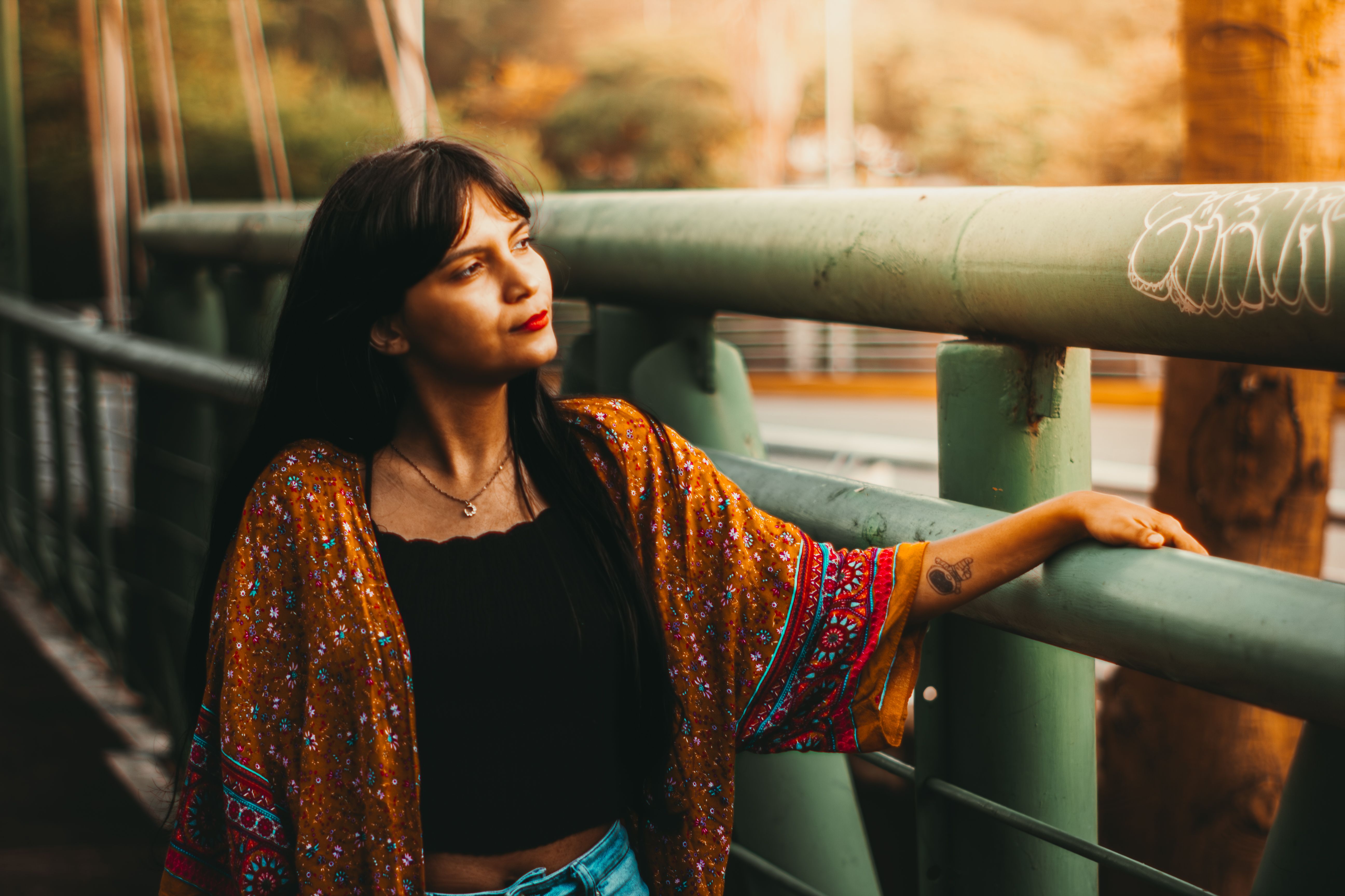 Contemplative Woman on a Bridge at Sunset · Free Stock Photo