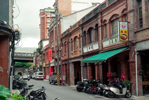 Free Charming view of historic brick buildings and street life in Taipei City's vibrant neighborhood. Stock Photo