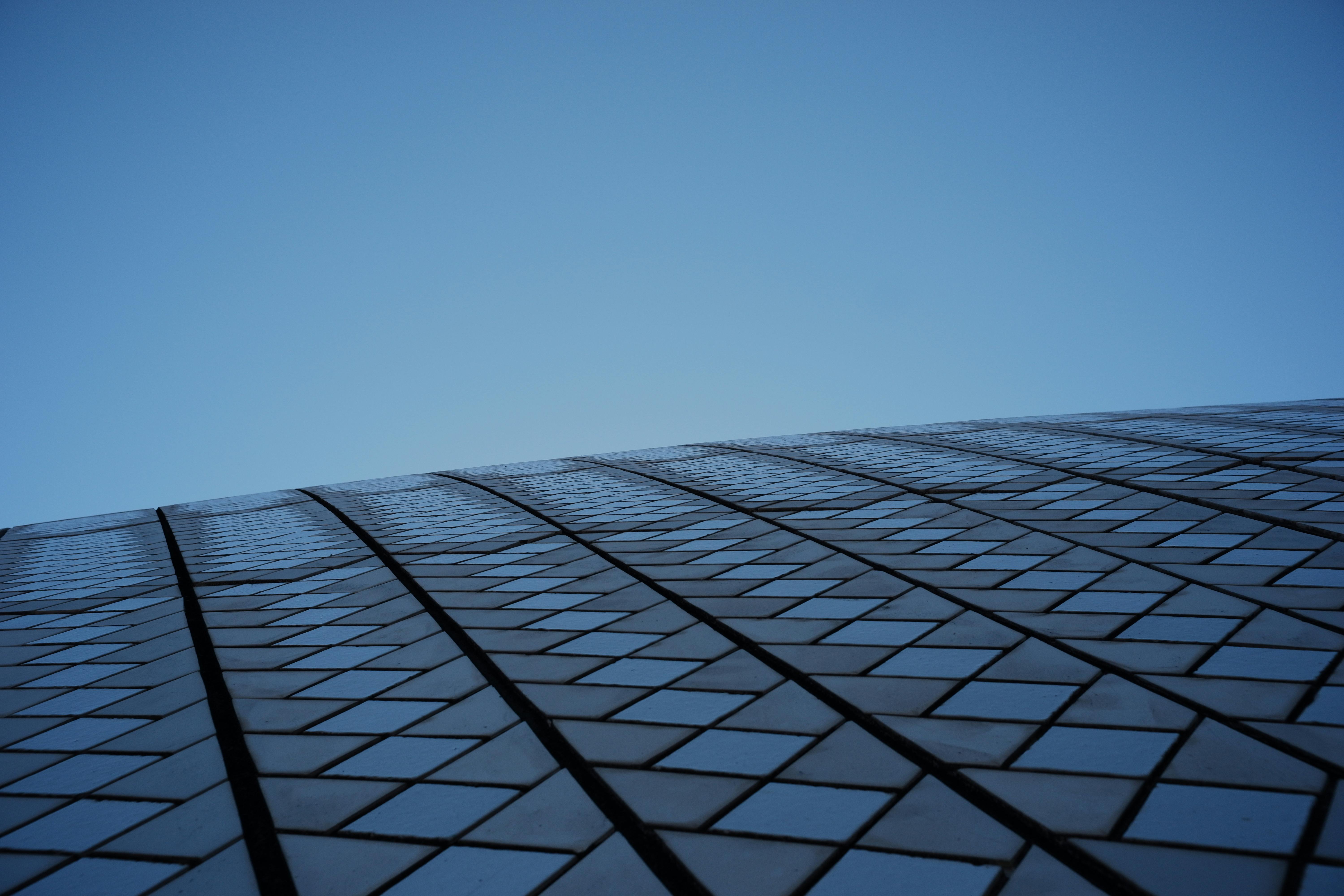 Kostenlos Faszinierender Anblick eines modernen Architekturdesigns, das geometrische Muster vor einem klaren blauen Himmel zeigt. Stock-Foto