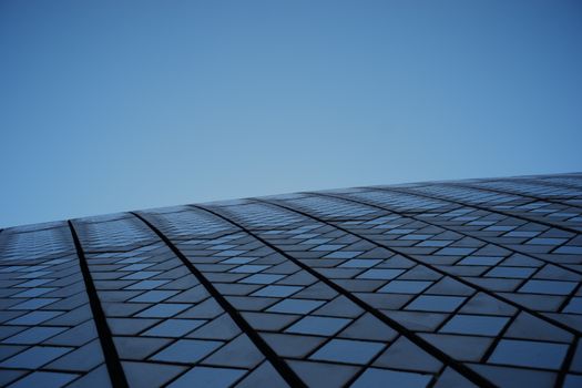Captivating view of a modern architectural design showcasing geometric patterns against a clear blue sky.