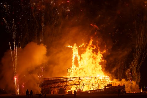 Free A vibrant display of fire and fireworks at the iconic Burning Man Festival, captured during a night event. Stock Photo