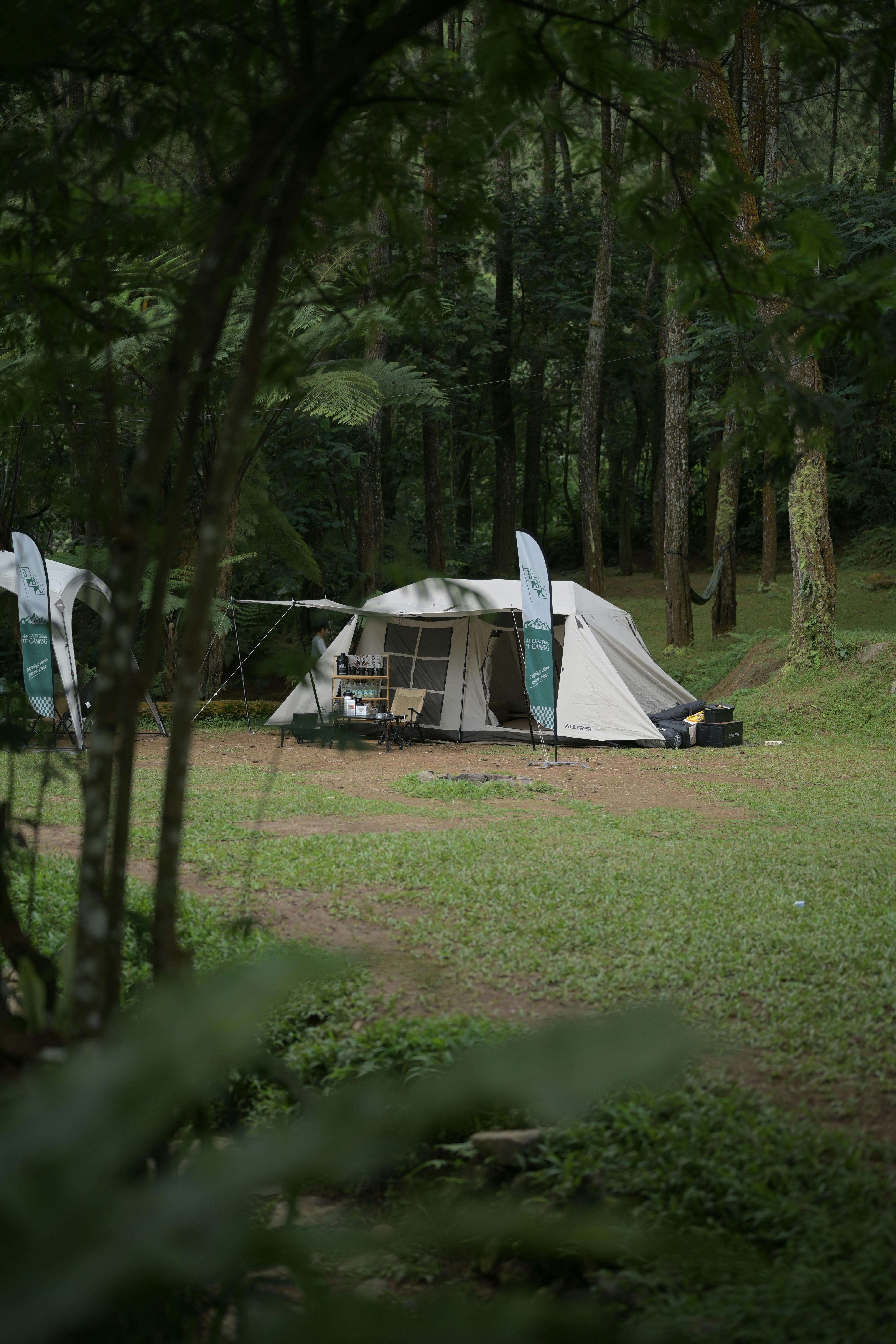 Oztent RV-5 camping tent pitched at a quiet bush campsite with gear neatly organized