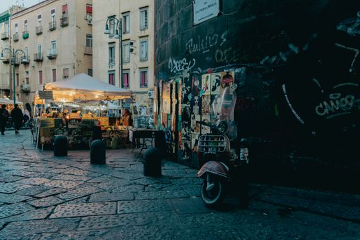 Discover a bustling evening street market scene in historic Naples, Italy.