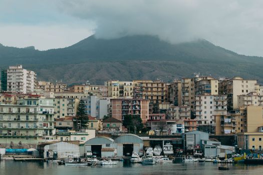 Vibrant city view of Naples with Mount Vesuvius in the background, highlighting classic architecture.