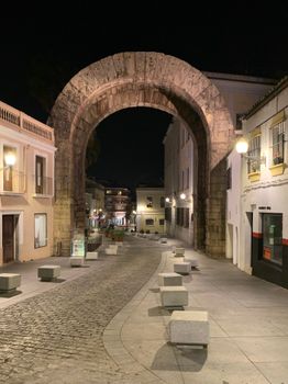 Night view of the ancient Roman archway in Mérida, Spain, beautifully lit against the night sky.