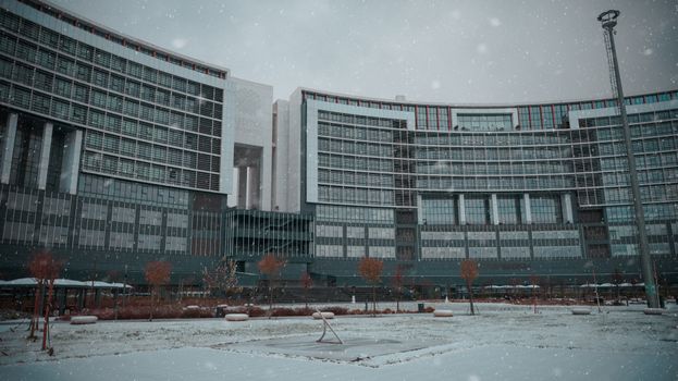 A panoramic view of a modern building in Istanbul covered in snow during winter.