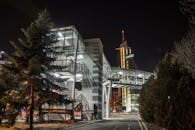 这座照明人行桥位于夜间城市环境中，展现了现代建筑风格