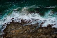 南非海豚海岸的戏剧性鸟瞰图：海浪拍打着岩石海岸线