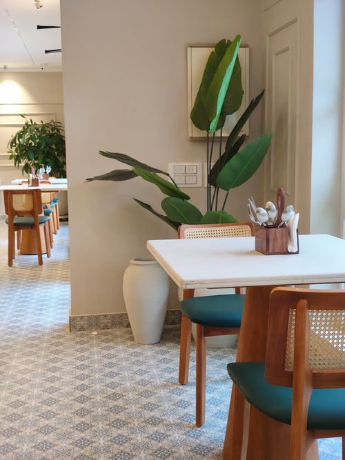 Free A stylish café interior with wooden furniture and large potted plants in Thrissur, India. Stock Photo