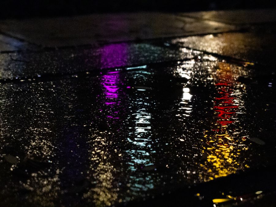 Neon light reflected on wet pavement at night. Photo by Will Chen on Pexels