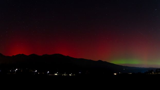 Captivating view of the Northern Lights illuminating the night sky over Veneto, Italy.