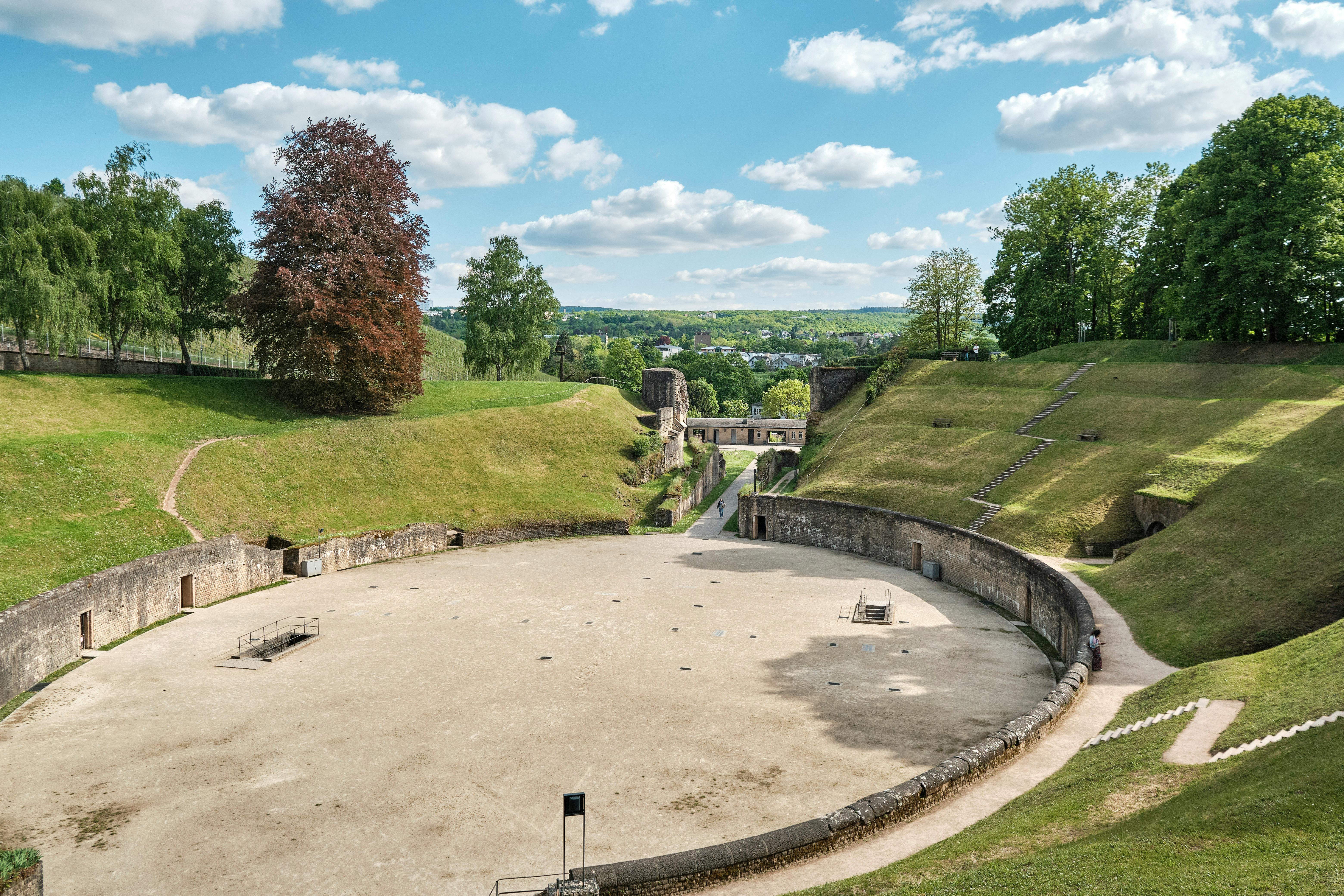 Kostenlos Historische römische Amphitheaterruinen in Trier, Deutschland, unter strahlend blauem Himmel. Stock-Foto