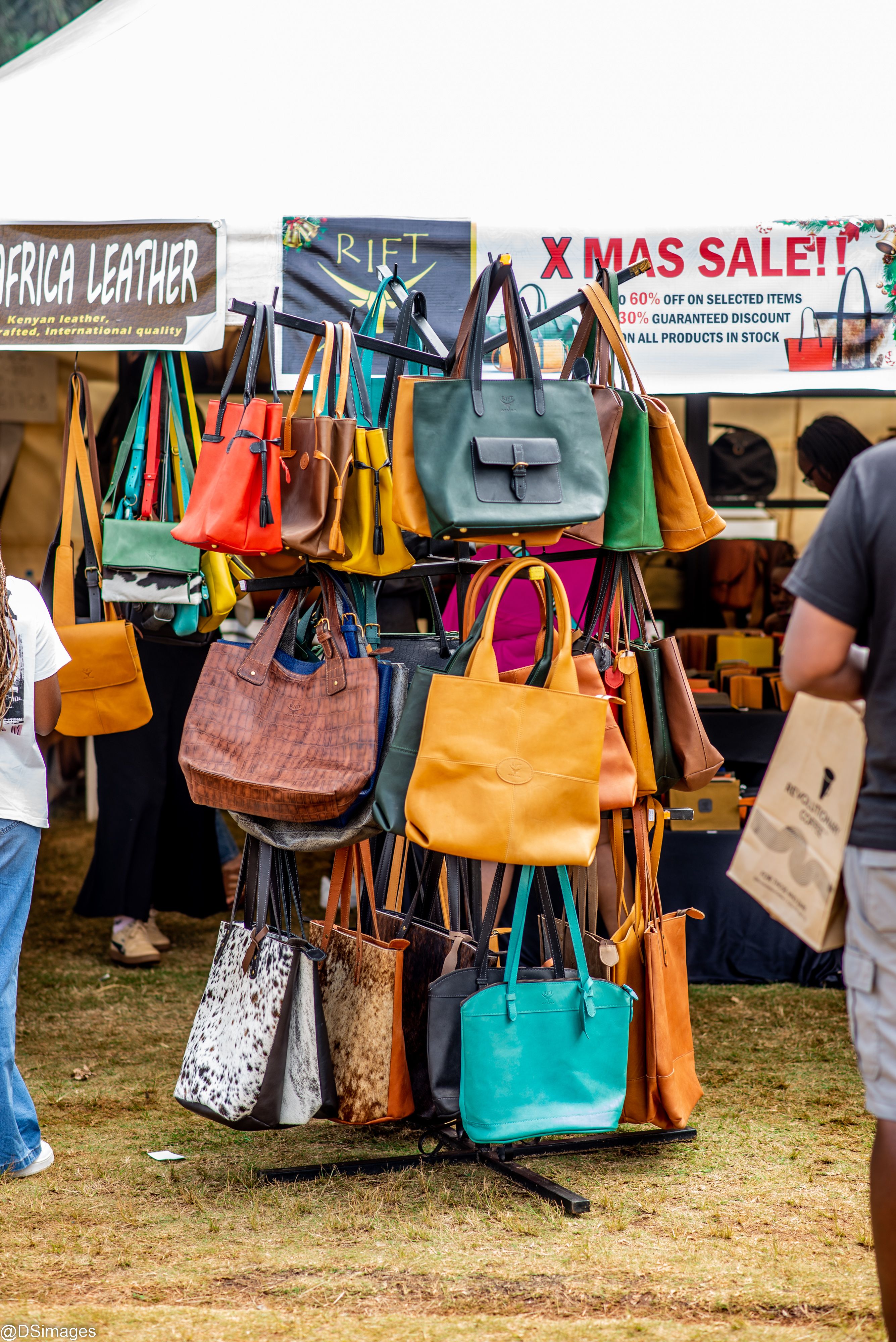 Vibrant leather handbags displayed at an outdoor market stall with a seasonal Xmas sale sign. - Tips for Online Shopping and What to Look For