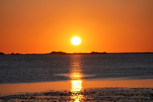 Captivating sunset over the ocean with vivid orange hues and calm waters.