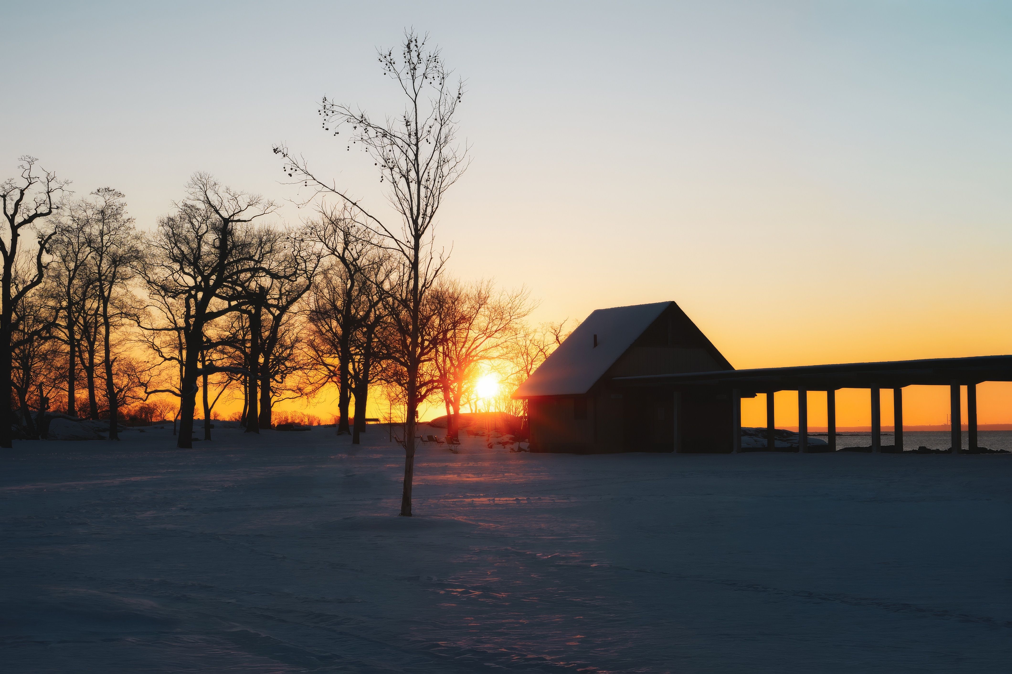 Serene Winter Sunset Over a Quiet Snowy Landscape · Free Stock Photo