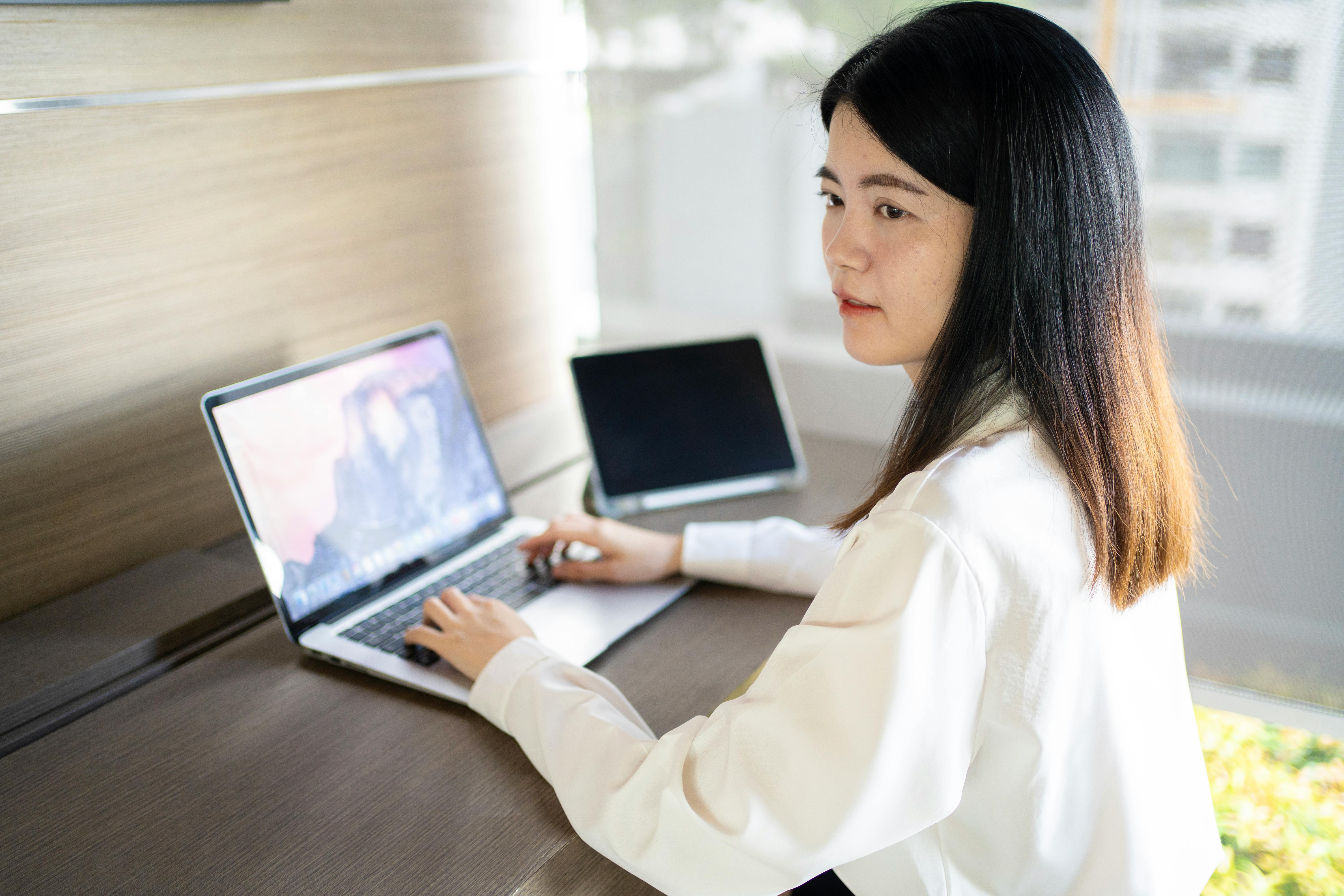 Confident Asian woman working remotely in a modern Bangkok office setting.