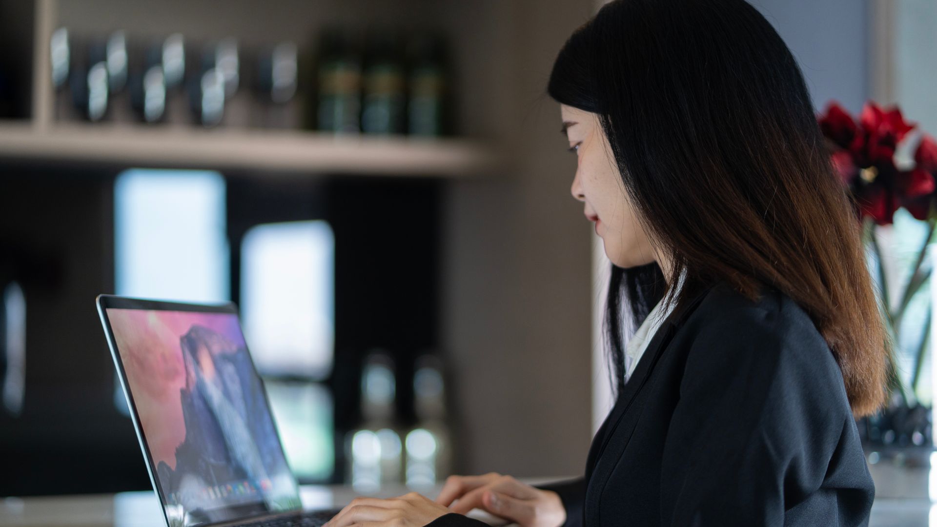 Modafinil for Remote Workers: Boosting Focus and Productivity Asian woman working on a laptop in a modern home office, blending productivity and style — modafinil for remote workers