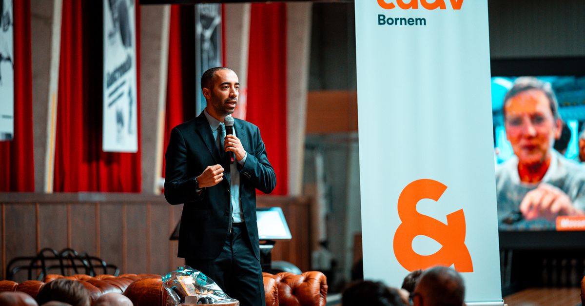 Male speaker presenting at a corporate event. Audiences are engaged indoors.